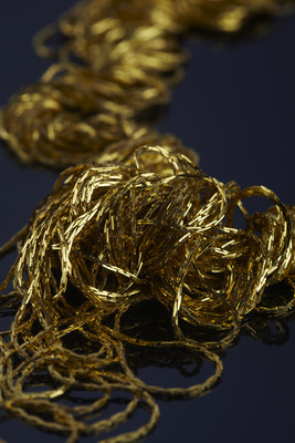 Украшение из тонких металлических нитей золотое